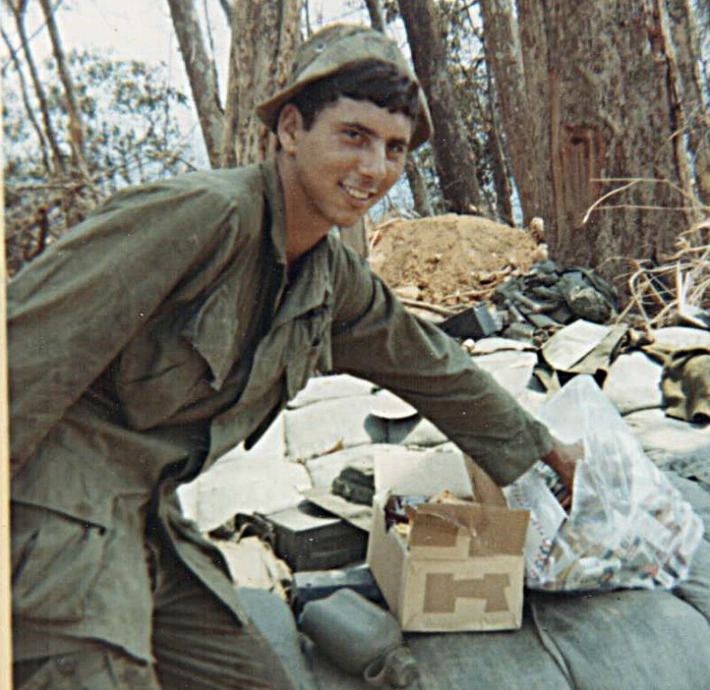 Tom Lacombe in 1969 on LZ Swift hilltop on the Cambodian border checking his resupply for candy.